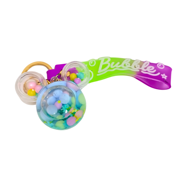 A transparent gumball machine keychain with colorful floating elements.