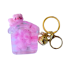 A cute pink liquid-filled house keychain with floating beads, featuring a small pig figure on top, attached to a gold