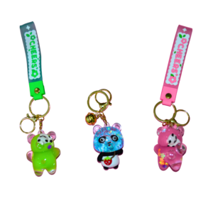 Three colorful panda-themed keychains with glitter-infused resin bear shapes, featuring metal keyrings, a detachable "CHEERS" silicone strap, and a glowing effect. The keychains come in green, blue, and pink variations.